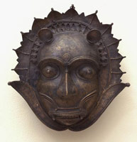 Unknown (India, Malabar Coast) / 
      Demon (Bhuta) Mask with Feline Ears and Whiskers, 19th century / 
      bronze / 
      10 7/8 x 10 7/8 x 4 3/4 in. (27.6 x 27.6 x 12.1 cm) / 
      Private collection / 
        / 
      The three masks on view in this exhibition, depict
      demons, or <em>Bhutas</em>, and
      were worn by Tulu devotees associated with the cult of the Mother Goddess.
      Danced reenactments of the principle myths and legends of the Mother
      Goddess were performed during the great festivals that marked religious
      life along the Malabar Coast in southern India.  In these epiphanic
      religious festivals, it is believed the demon comes to inhabit the
      body of the dancer, and is later ritually slain by the mother goddess
      herself. 
