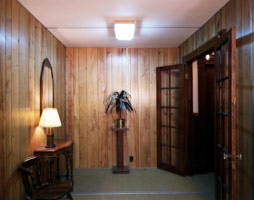 Edward & Nancy Kienholz / 
The Pedicord Apartments, 1982 - 83 / 
Tableau: wood, wallpaper, furniture, doors, carpet, light fixtures, artificial plants, linoleum, floor mats, mirror, fireplace, tape recorders, fluorescent lights, marquee, plants, and polyester resin / 
108 x 192 x 432 in (274.3 x 487.7 x 1,097.3 cm) / 
Collection of the Frederick R. Weisman Art Museum, Minneapolis, MN